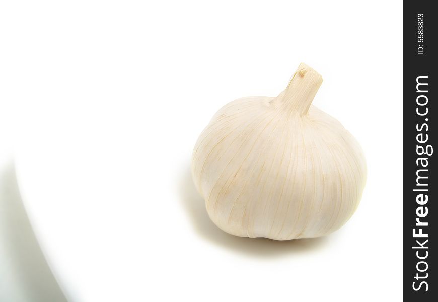 A bulb of garlic on white plate and isolated on white background