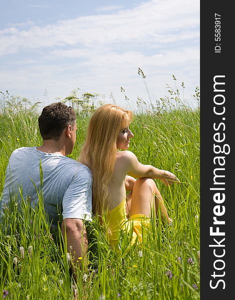 Attractive couple enjoying togetherness on meadow in summer day