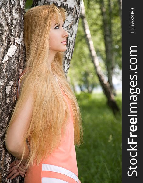 Young Woman Leaning Against Birch In Forest