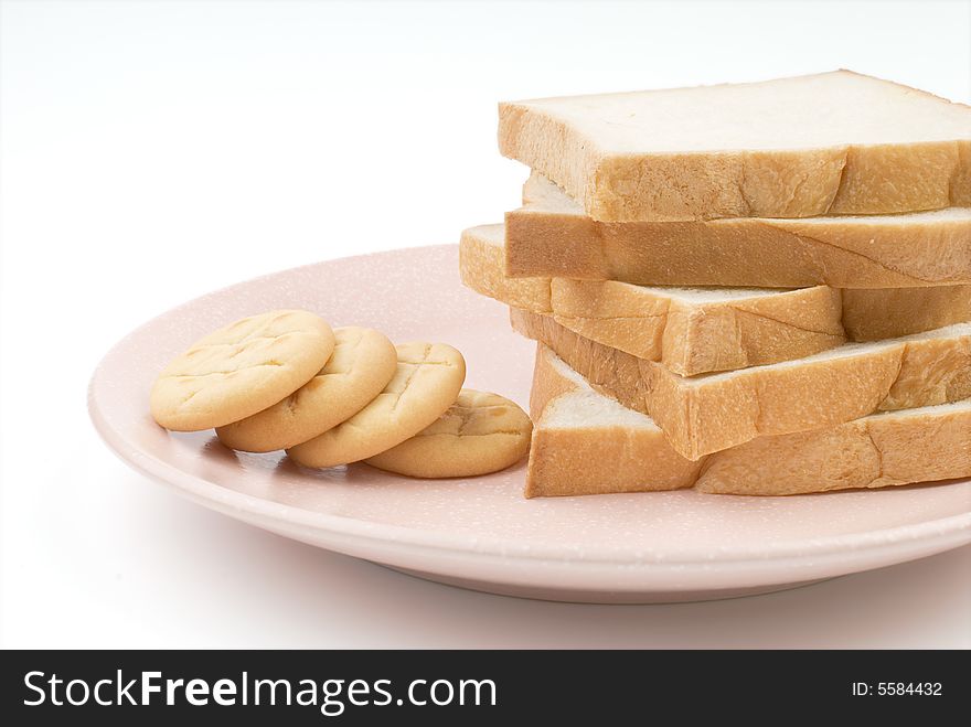 Toast and cookies in the plate with white background.