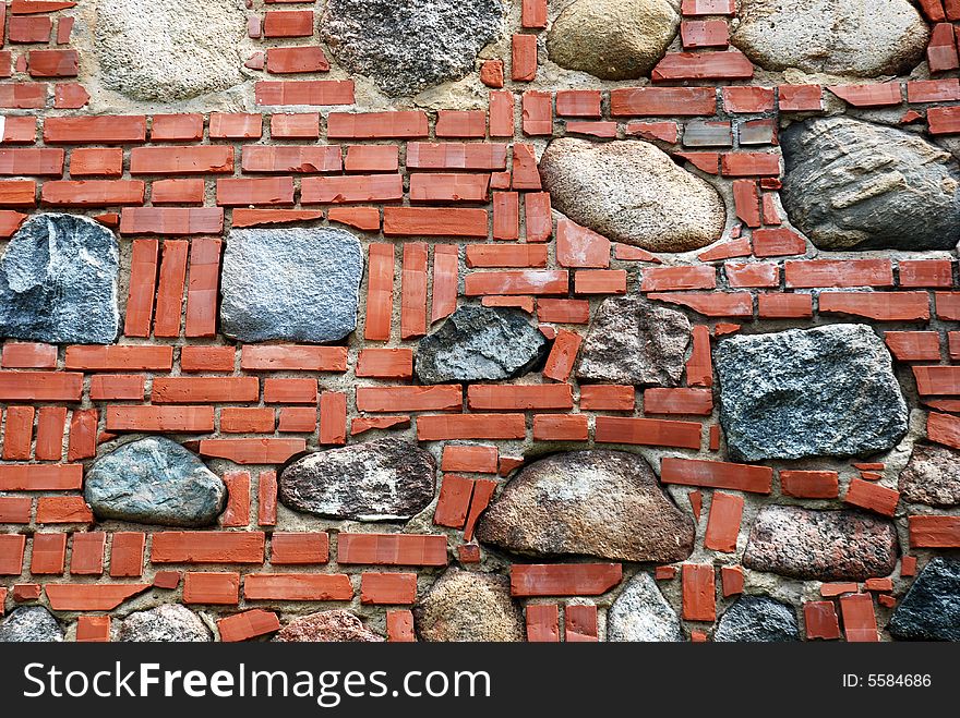 The wall made of bricks and stones. The wall made of bricks and stones