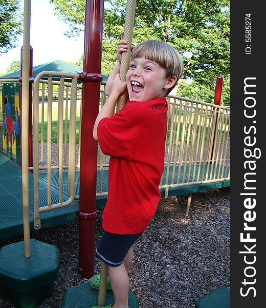 A young boy laughs at the playground. A young boy laughs at the playground