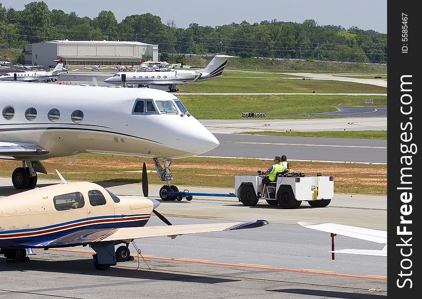 A towing vehicle pulling a jet off the runway. A towing vehicle pulling a jet off the runway