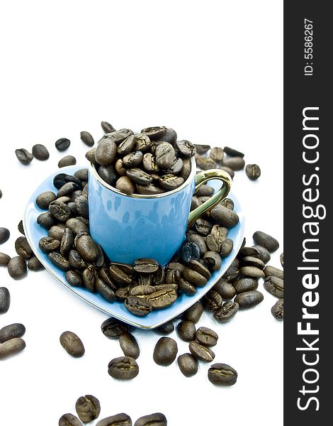 Blue cup with seeds a of coffee on a white background. Blue cup with seeds a of coffee on a white background