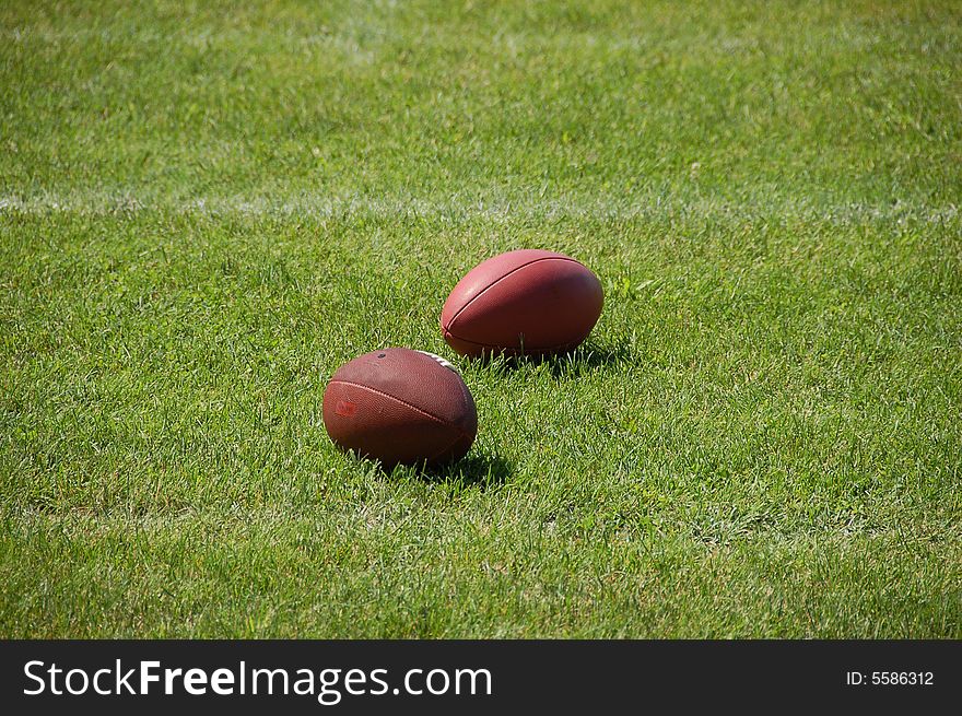 Two American Football balls on the grass. Two American Football balls on the grass
