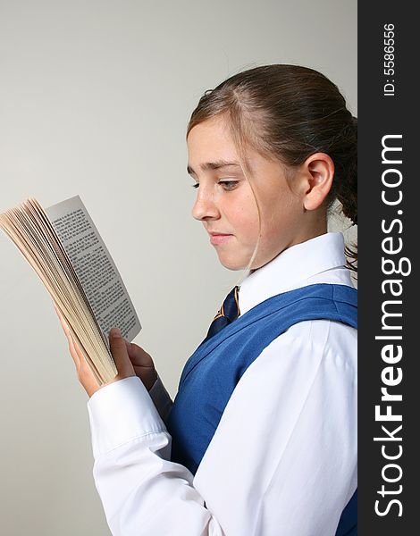 Teenage School girl reading a book, wearing uniform