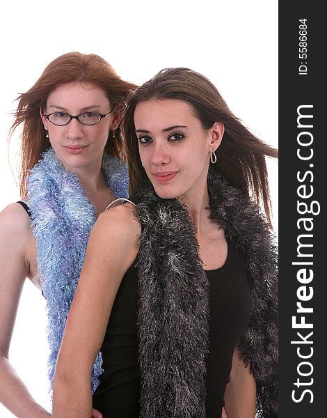 Two beautiful teenage girls with windblown hair and fluffy scarfs