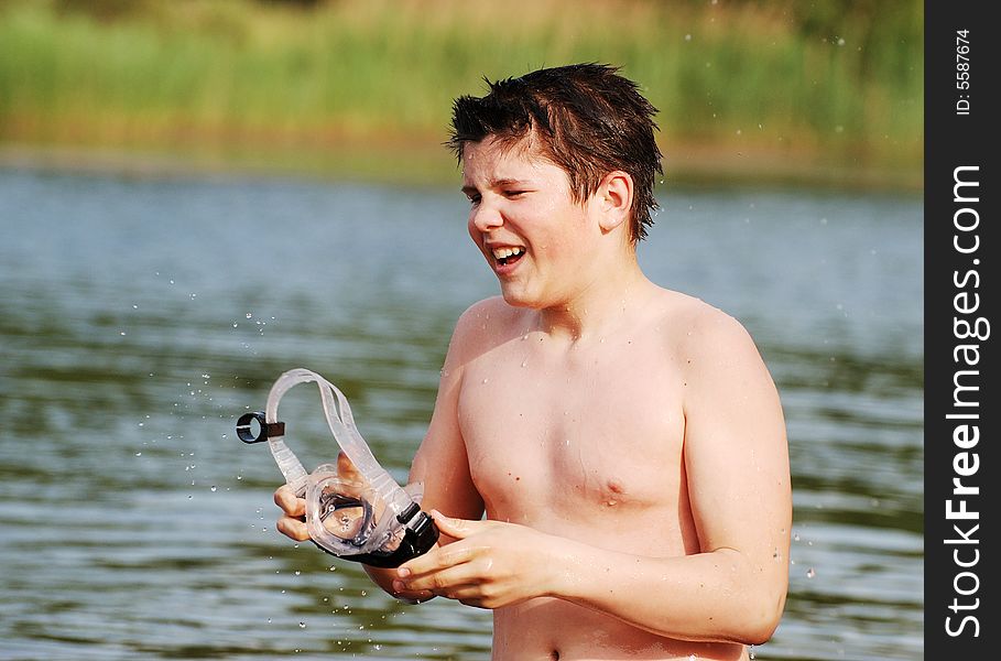 The boy with goggles having fun in a small lake (Lithuania). The boy with goggles having fun in a small lake (Lithuania).
