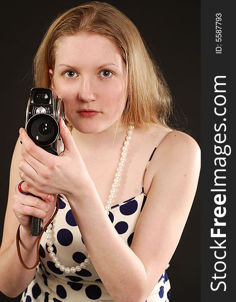 Long haired girl holding a vintage movie camera