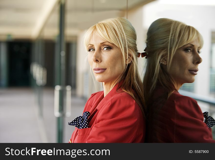 Blonde Businesswoman leaning against a reflective surface. Blonde Businesswoman leaning against a reflective surface