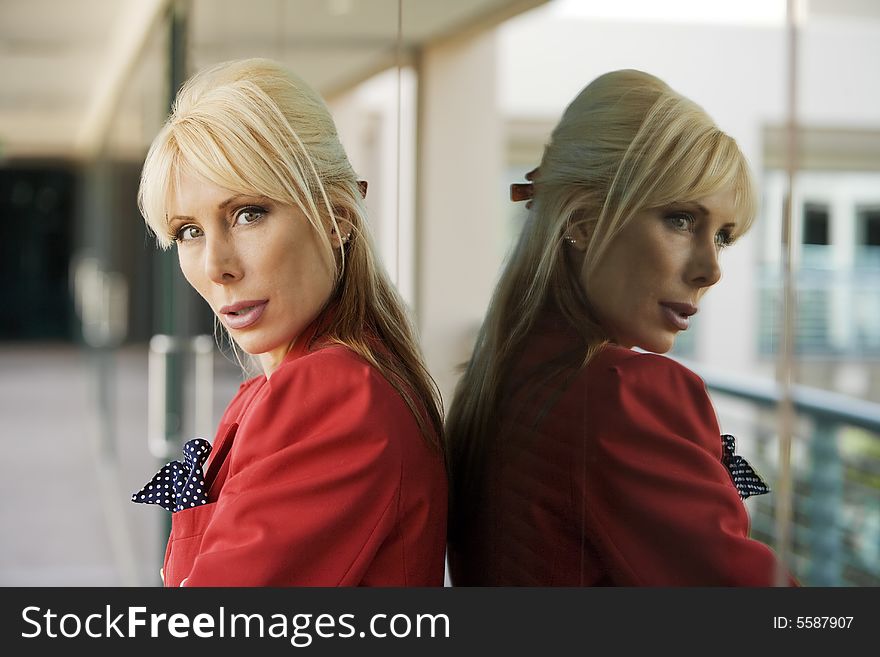 Blonde Businesswoman leaning against a reflective surface. Blonde Businesswoman leaning against a reflective surface