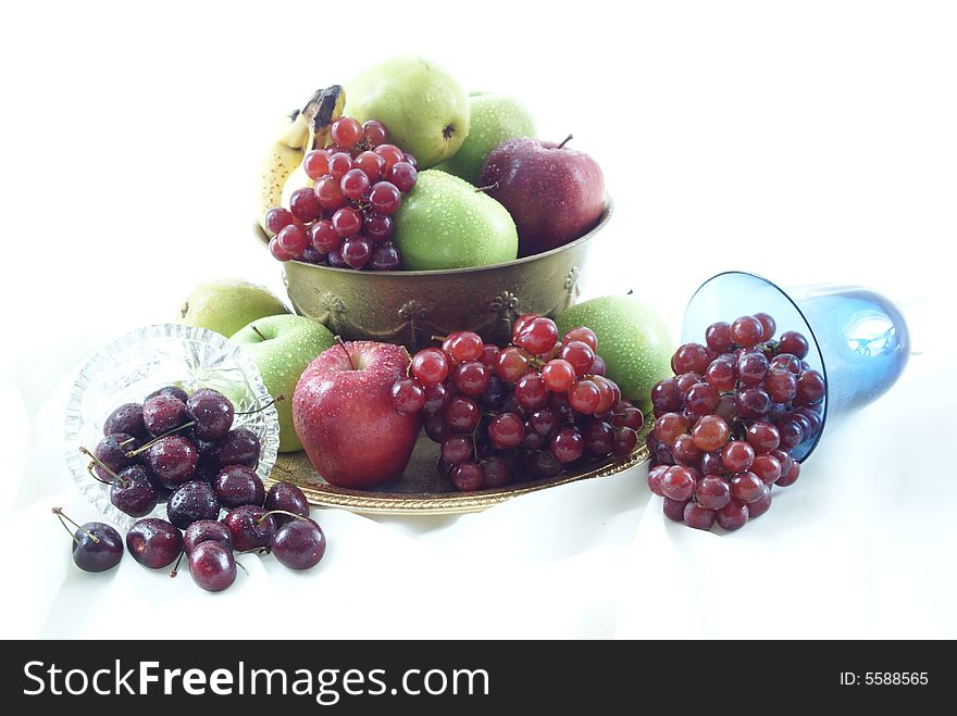 Silver candle and blue goblet with overflowing fruit bowl. Silver candle and blue goblet with overflowing fruit bowl.