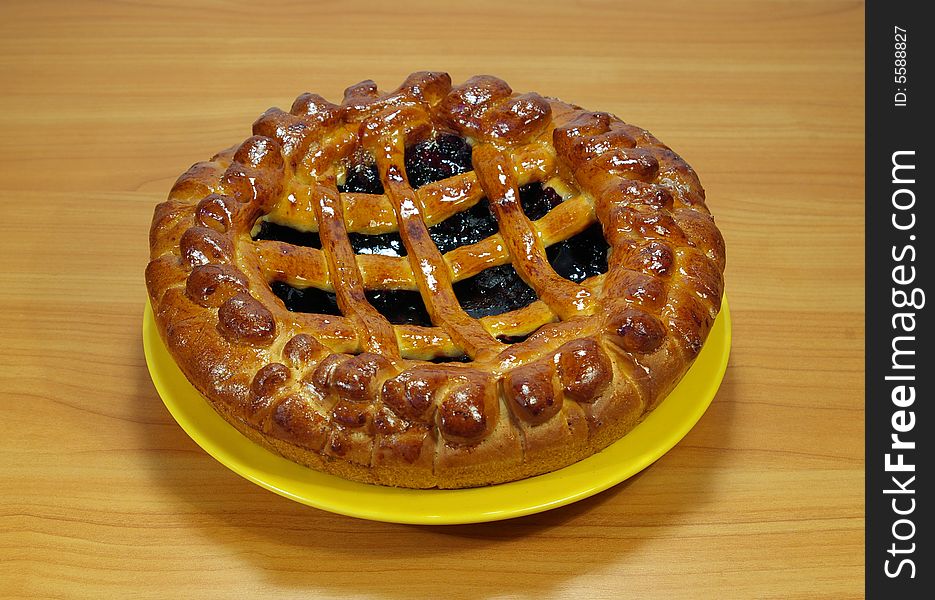 Fresh sweet pie with bilberry on a yellow plate