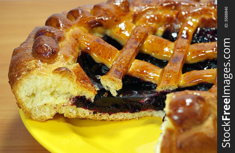 Fresh sweet pie with bilberry on a yellow plate. Fresh sweet pie with bilberry on a yellow plate