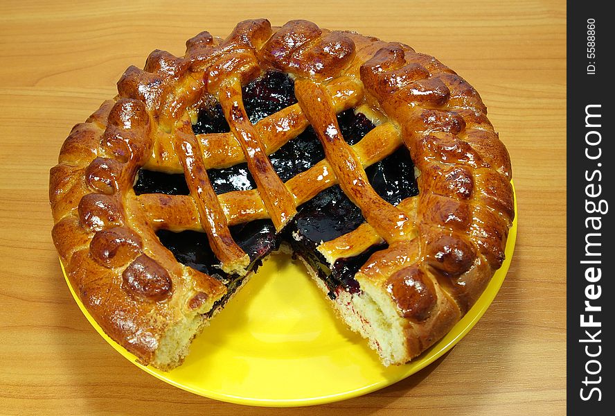 Fresh sweet pie with bilberry on a yellow plate. Fresh sweet pie with bilberry on a yellow plate