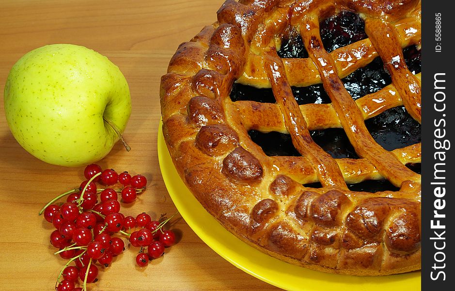 Fresh sweet pie with bilberry on a yellow plate. Fresh sweet pie with bilberry on a yellow plate