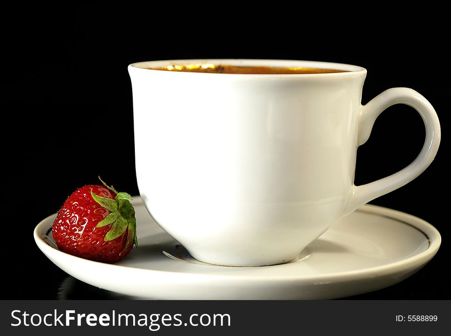 Cup of coffee and strawberry on a black background