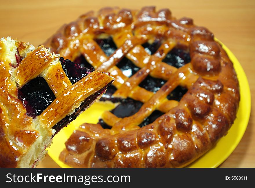 Fresh sweet pie with bilberry on a yellow plate. Fresh sweet pie with bilberry on a yellow plate