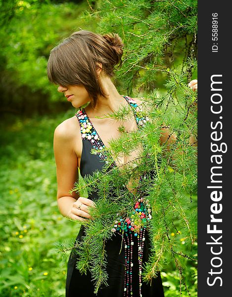 Beauty young girl in black dress in the woods