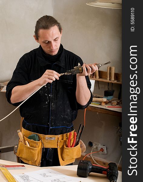 Carpenter prepare pneumatic chisel  in his workshop