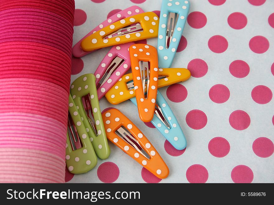 Brightly colored polka dot hair accessories on a polka dot background