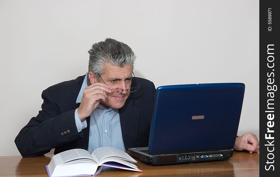 A businessman working in his study with a computer. A businessman working in his study with a computer