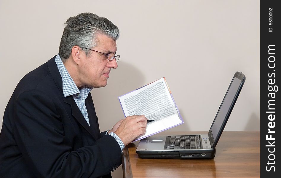 A businessman working in his study with a computer. A businessman working in his study with a computer