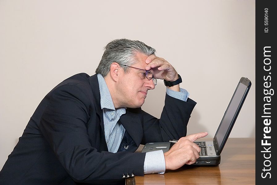 A businessman working in his study with a computer. A businessman working in his study with a computer