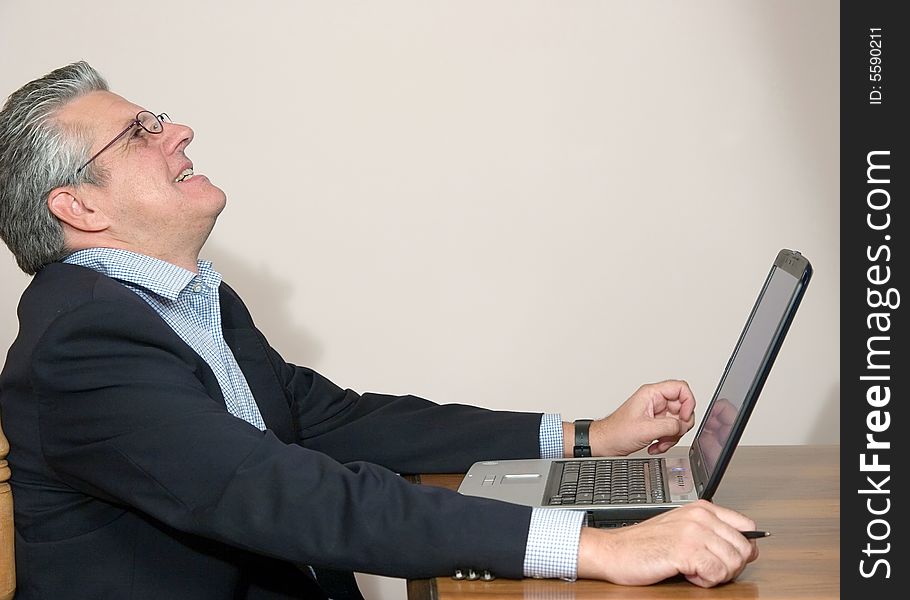 A businessman working in his study with a computer. A businessman working in his study with a computer