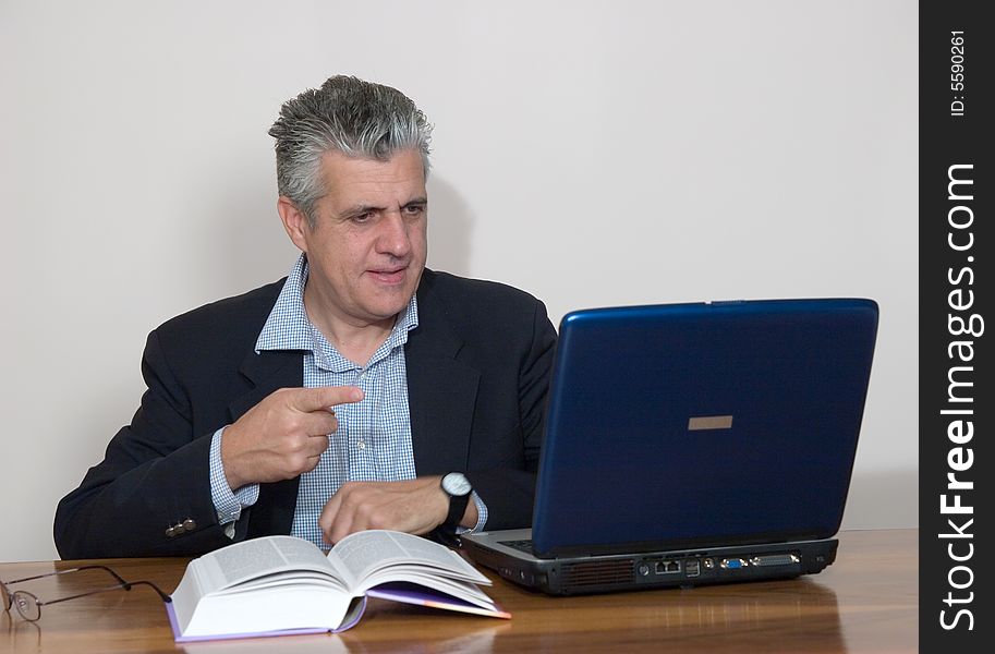 A businessman working in his study with a computer. A businessman working in his study with a computer