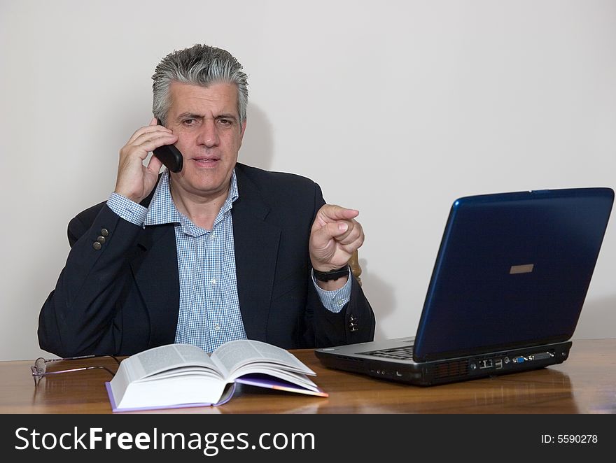 A businessman working in his study with a computer. A businessman working in his study with a computer