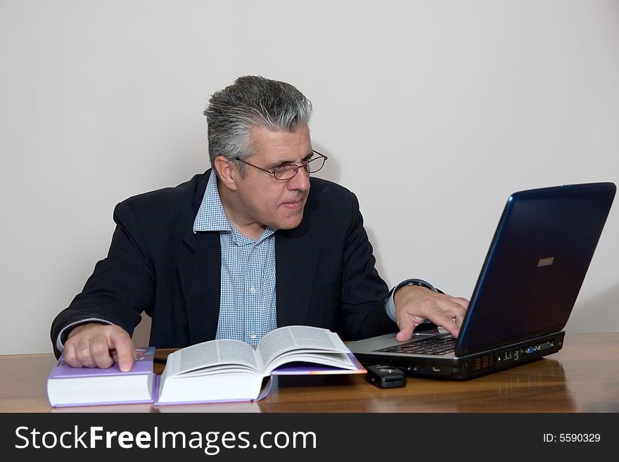 A businessman working in his study with a computer. A businessman working in his study with a computer