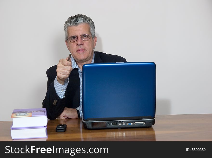 A businessman working in his study with a computer. A businessman working in his study with a computer