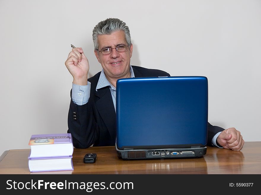 A businessman working in his study with a computer. A businessman working in his study with a computer