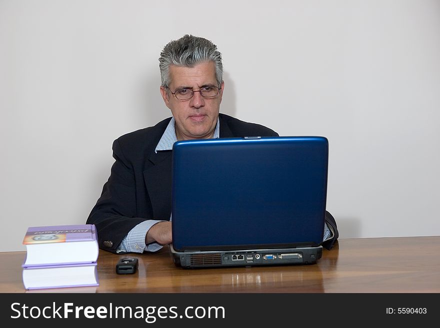 A businessman working in his study with a computer. A businessman working in his study with a computer