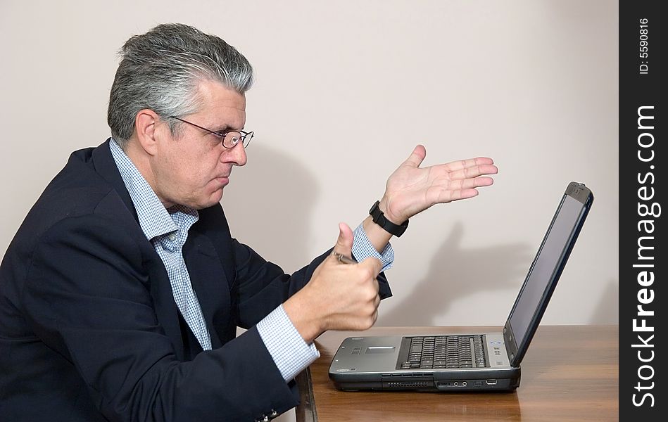A businessman while writing a report in his study in a very concentrated way with a computer. A businessman while writing a report in his study in a very concentrated way with a computer