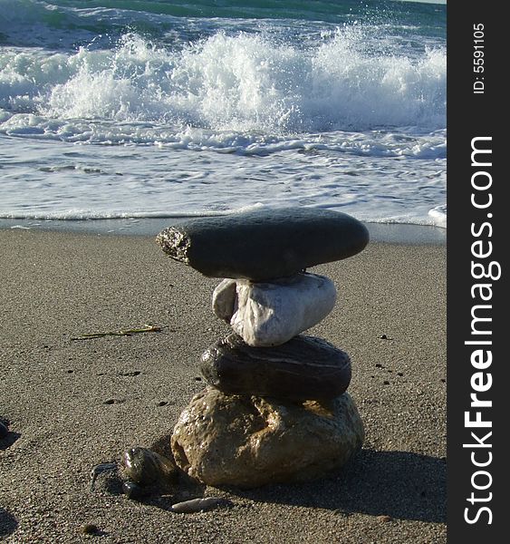 Pebble stack on the sand and sea as a background
