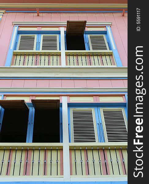 A colorful house with some of the shutters opened. A colorful house with some of the shutters opened