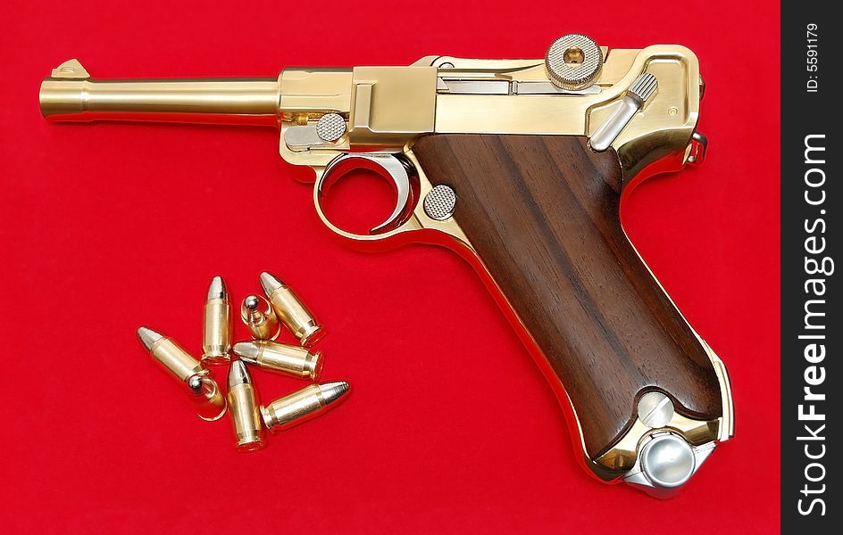 Golden gun isolated over a red background