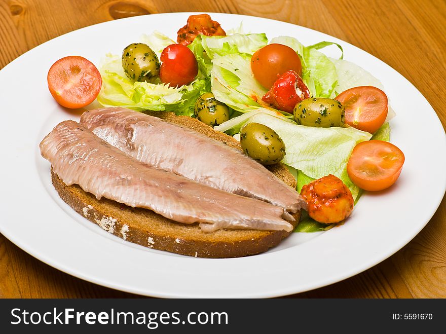 Herring and salad on a plate.