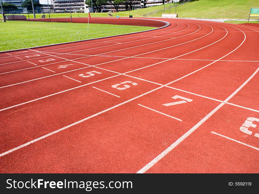 Red plastic raceway with white line in a sunny day.