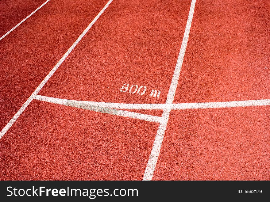 Red plastic raceway with white line in a sunny day.