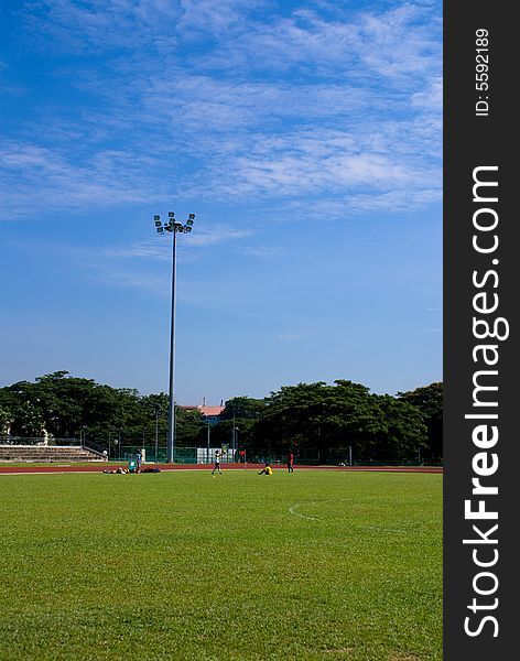 The refreshing campus scene in a university, the football field, the green grass, the floodlights, and the blue sky!. The refreshing campus scene in a university, the football field, the green grass, the floodlights, and the blue sky!