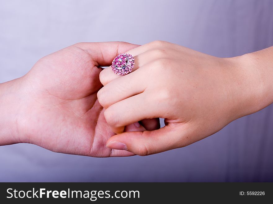 Hand in hand with a big purple diamond ring.