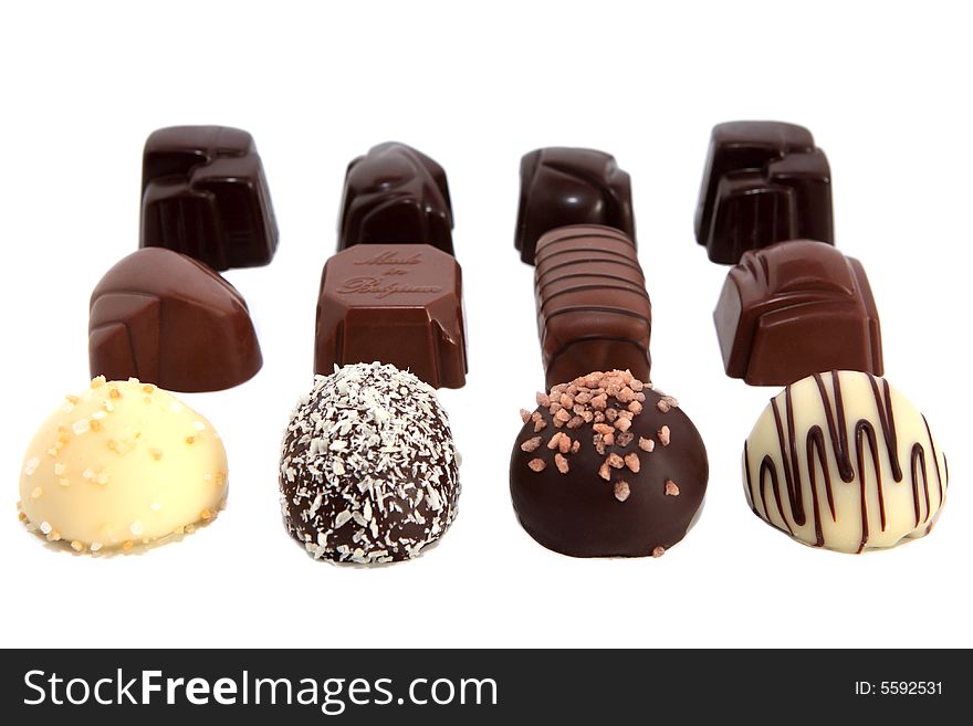 Twelve luxury chocolates in rows on white background. Twelve luxury chocolates in rows on white background