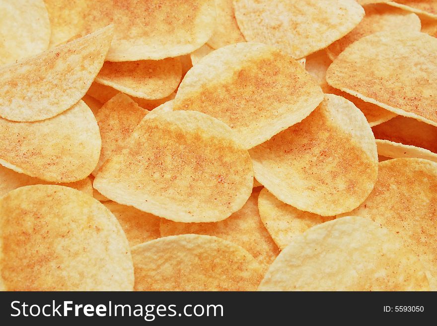 A pile of potato chips as food background.