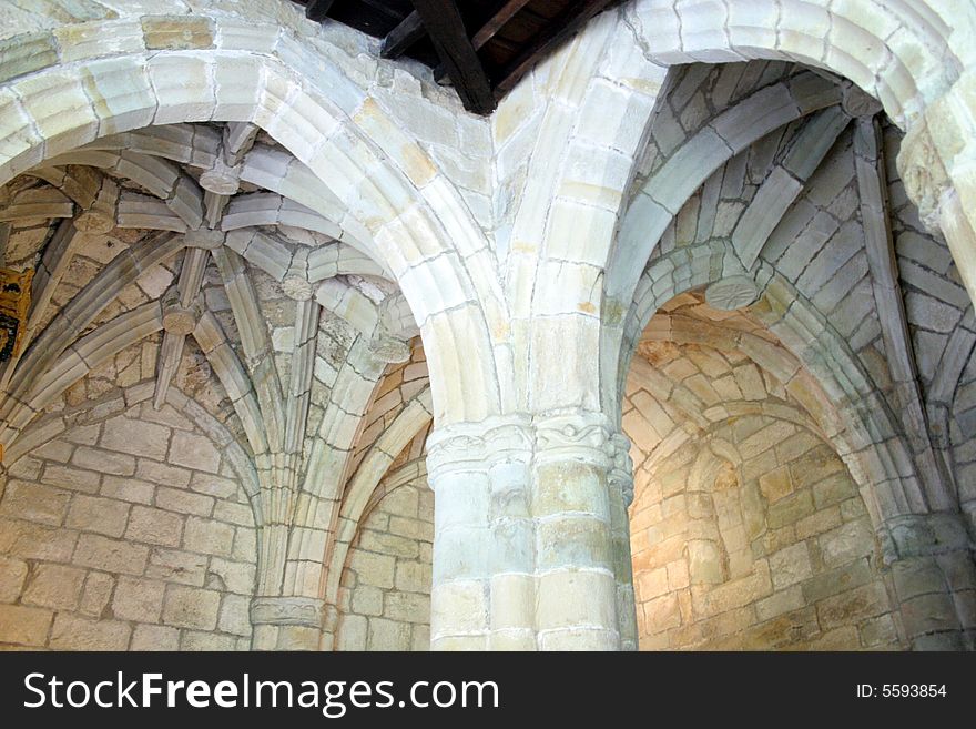 Ceilings with ribs, like a palm trees, arches, columns inside of cathedral in Santillana del Mar
