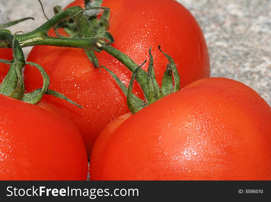 Tomatoes on a vine set on a rock