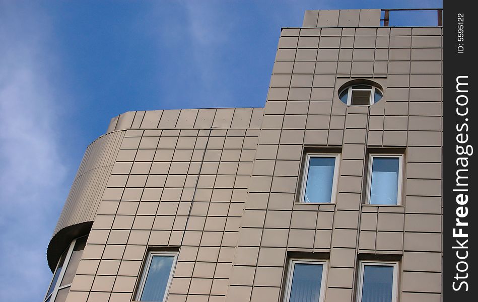 Front of modern office building over blue sky with clouds. Front of modern office building over blue sky with clouds