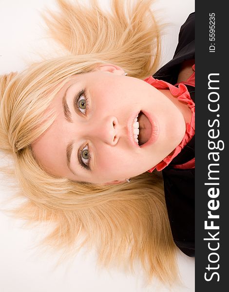 Portrait of astonished blond woman laying on the white floor